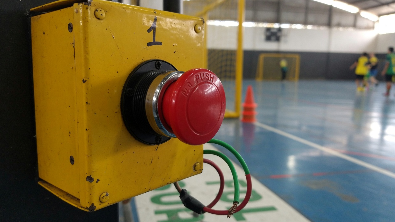 Botoeira vermelha de dois fios na borda da quadra